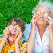 Happy grandmother and laughing <br />
 grandchild fooling around the law of putting chamomiles instead of eyes. Family love and relationships. Family happy holiday.; Shutterstock ID 1413780419; purchase_order: 12.05.2021; job: VIKA-2029-0002; client: Viatris; 