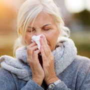 Sick woman blowing her nose